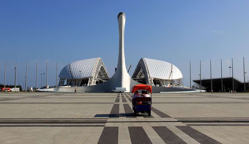 Чаша Олимпийского огня на фоне стадиона 